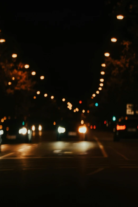 a night time view of cars driving on the road