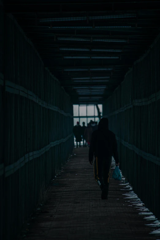 a man walks through a tunnel with people in the background