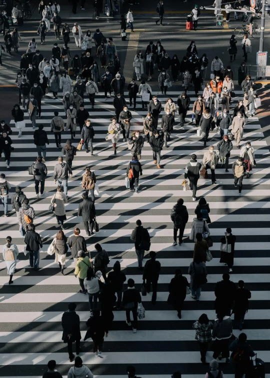 a group of people in a cross walk with an umbrella