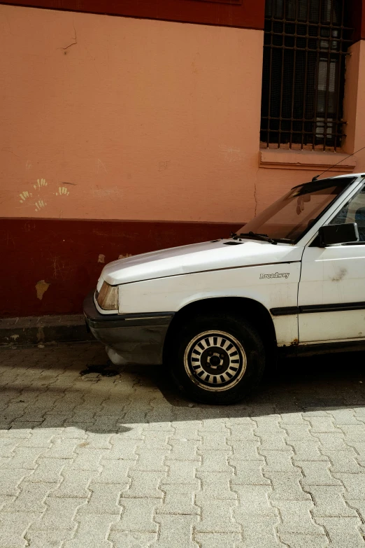 a dirty car parked next to a building