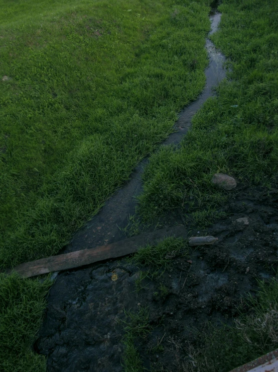 an old broken fire hydrant and grass field with a broken handle