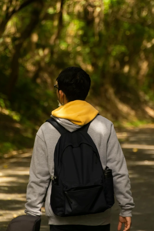 the young man in grey jacket is walking in street