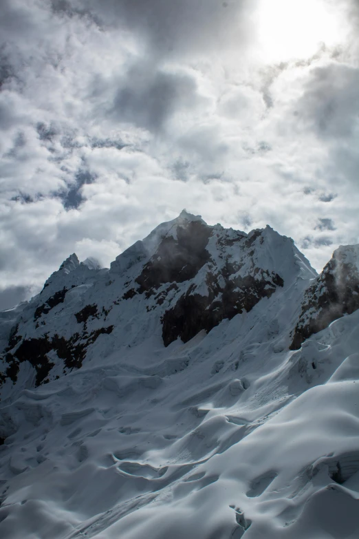 a snowy mountain in the middle of an overcast sky