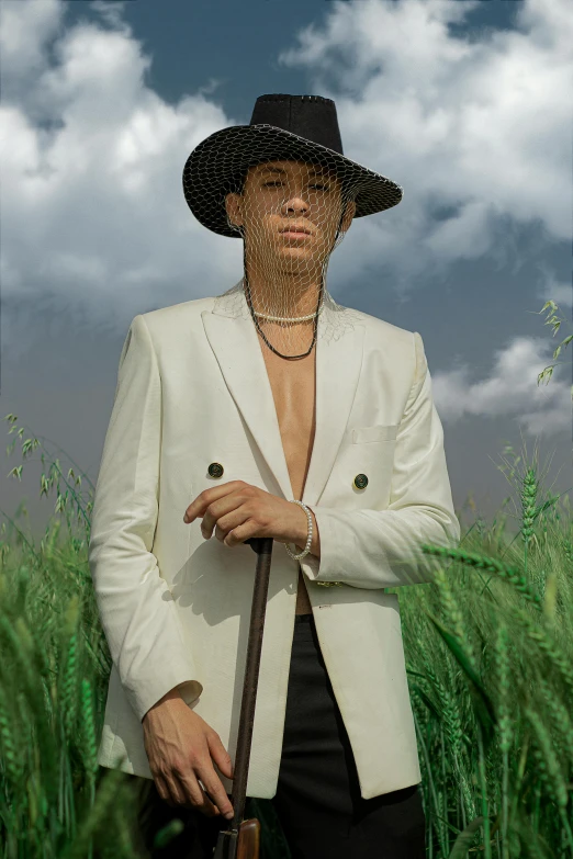 a person standing in tall grass wearing a hat