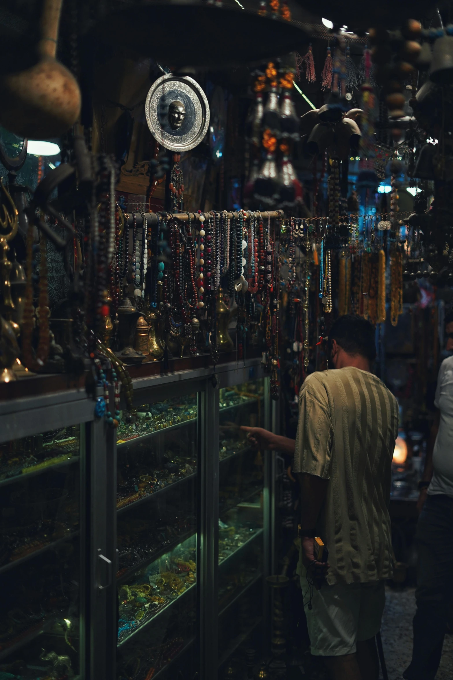 people are looking at jewelry in a display case