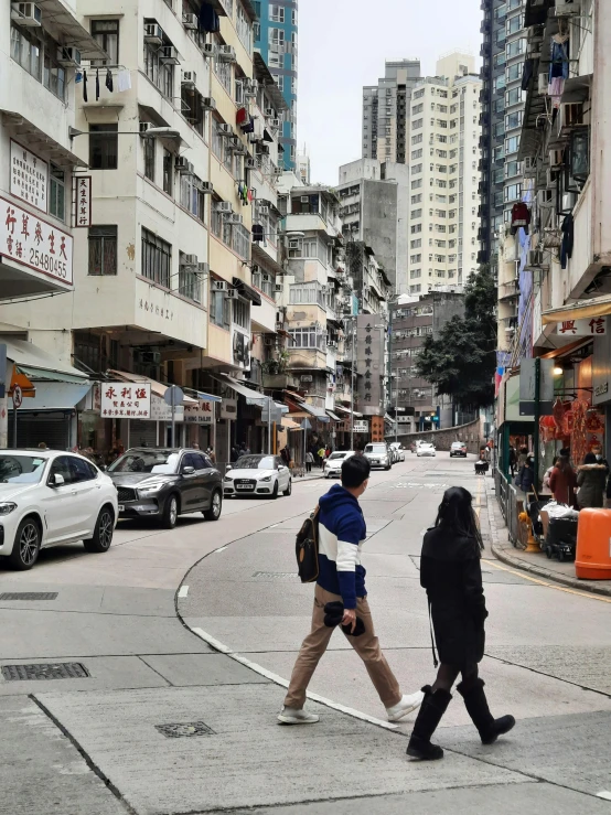 two people crossing the street in a city