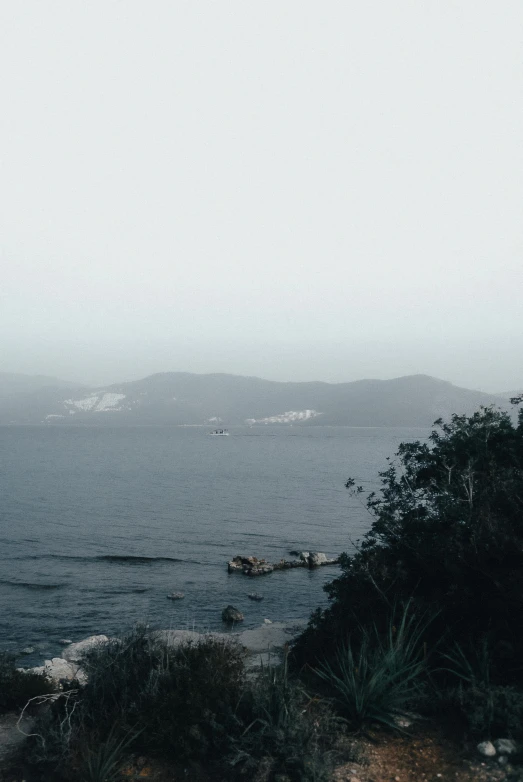 a dark landscape with water and grass