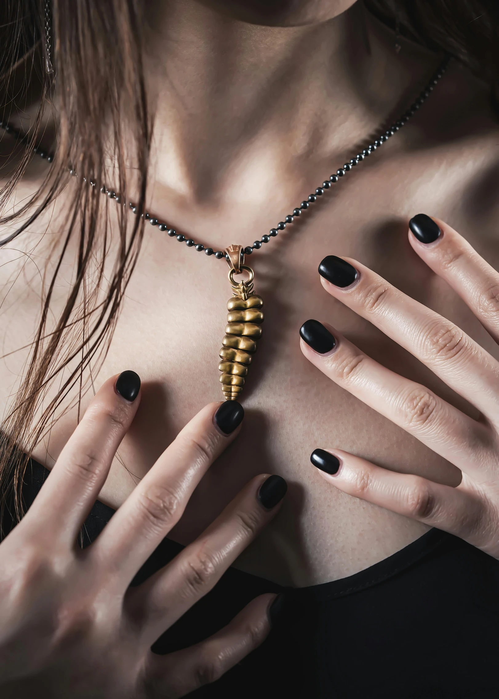 a woman in black and gold holding onto a golden key necklace