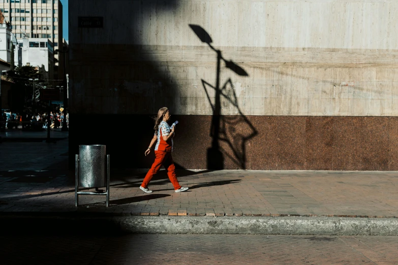 a woman walking past a light pole on a street