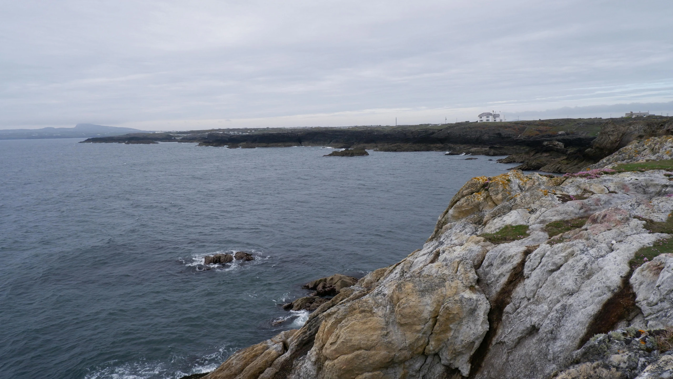 a body of water near a cliff with a few waves