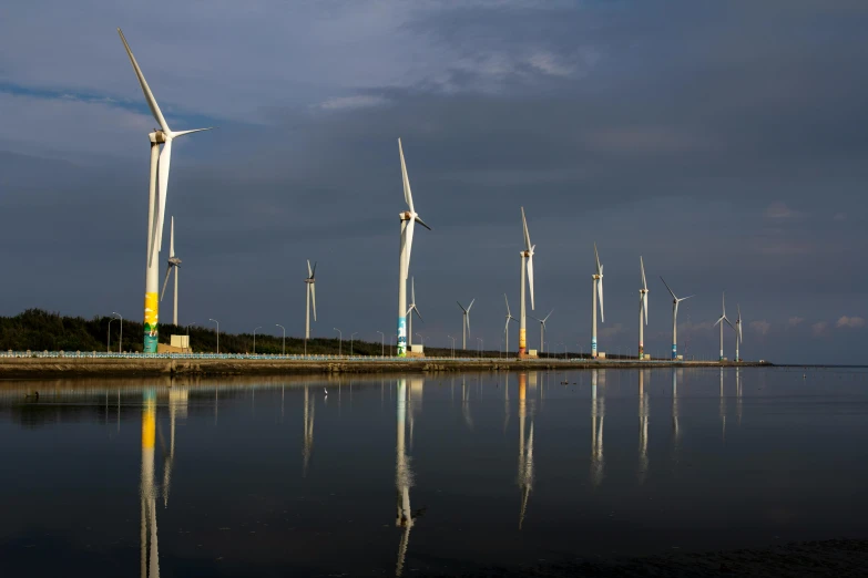 wind turbine farm surrounded by calm water and reflection