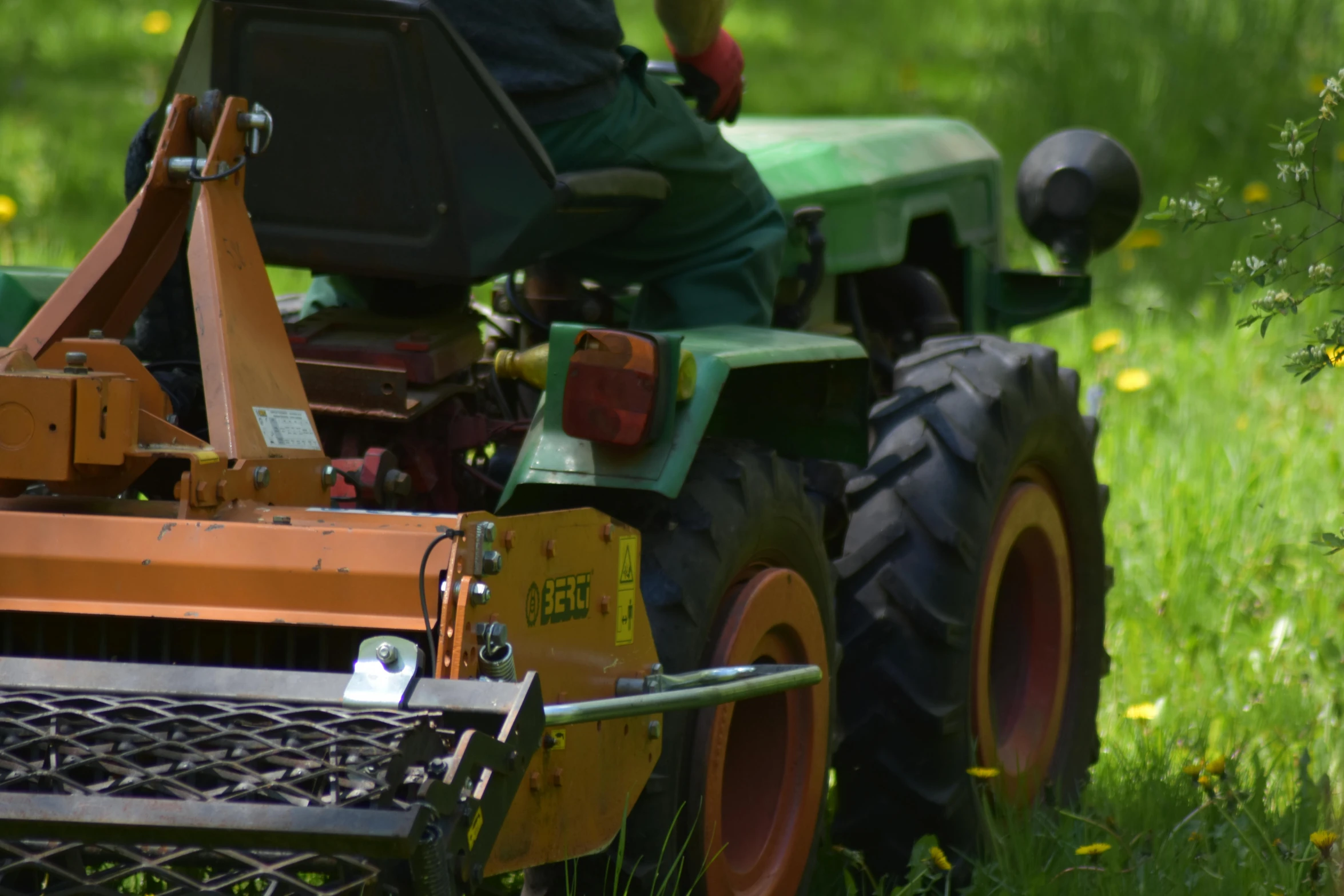 an older man mowing the grass in a field