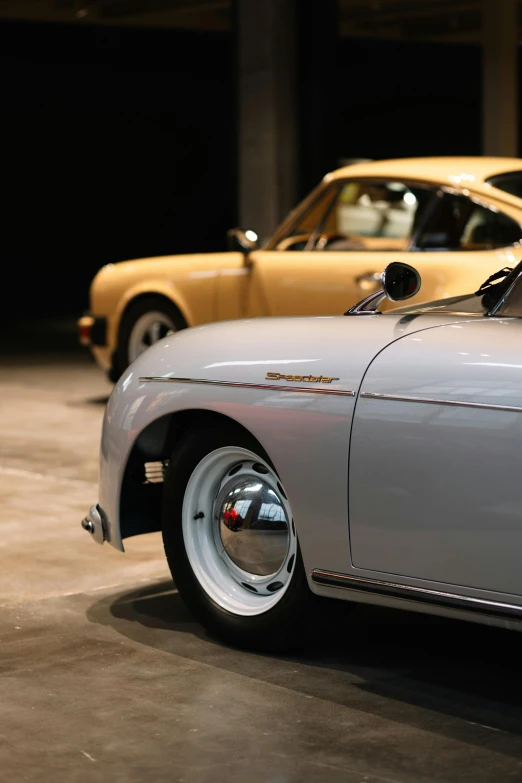 two old fashioned cars are parked side by side in a parking garage