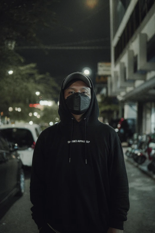 a man with a breathing mask walks down a dark street