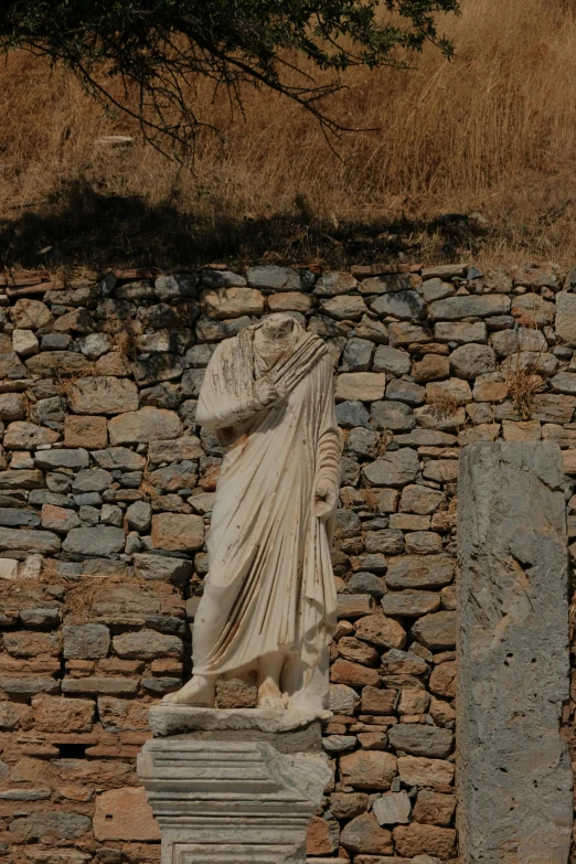 a very tall stone statue in the corner of a wall