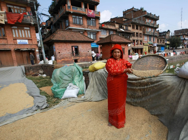 the woman is posing near her piles of straw