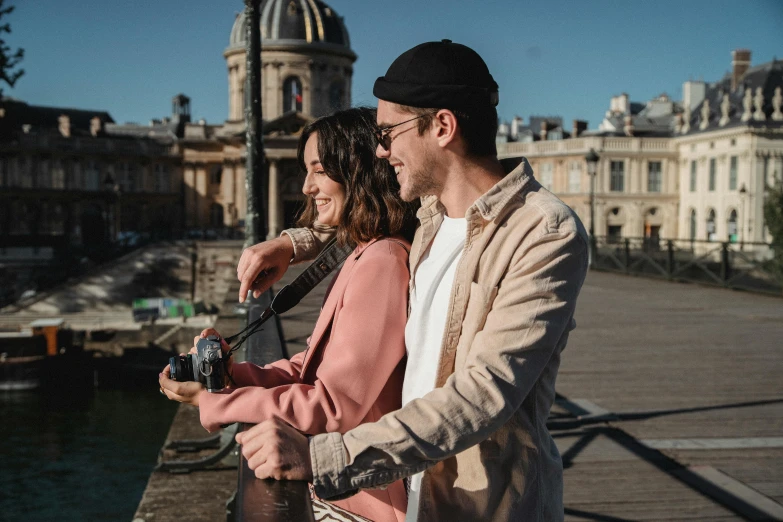 a couple taking pictures next to the water in the day time