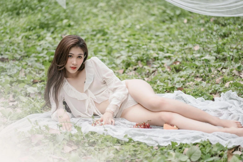 a woman is lying down on a blanket in the grass
