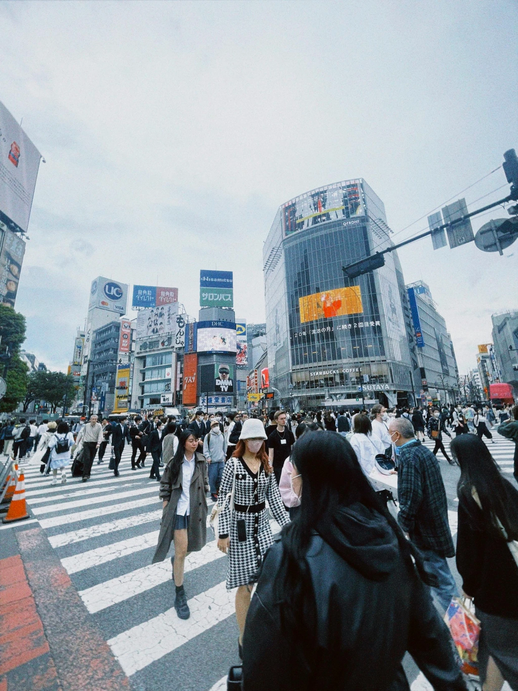 many people walk in the street near a crosswalk