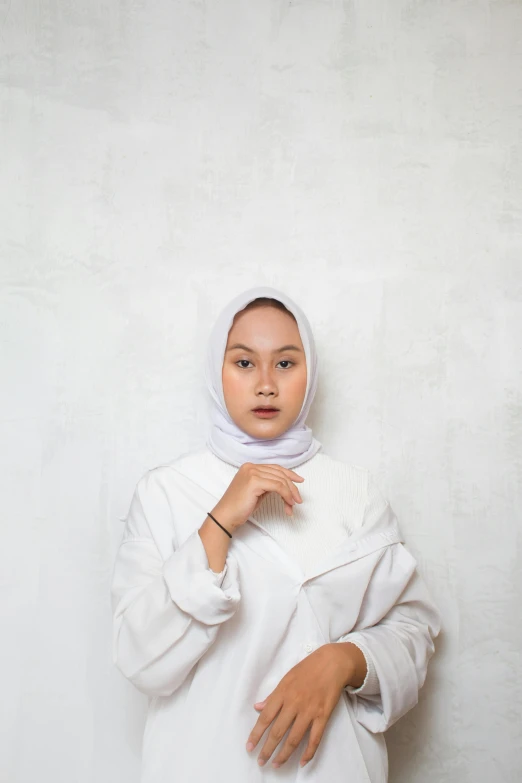 an asian female wearing a white dress and a hijab
