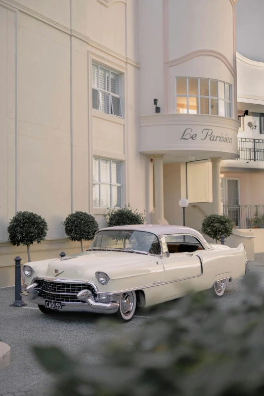 an old car parked next to a tall building