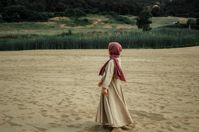 a woman in a red head scarf on a dirt field