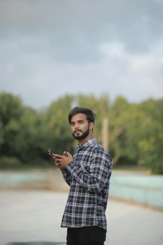 man standing with cellphone while looking off to the left