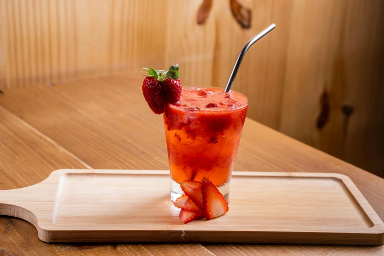 a glass with some strawberries in it on a tray