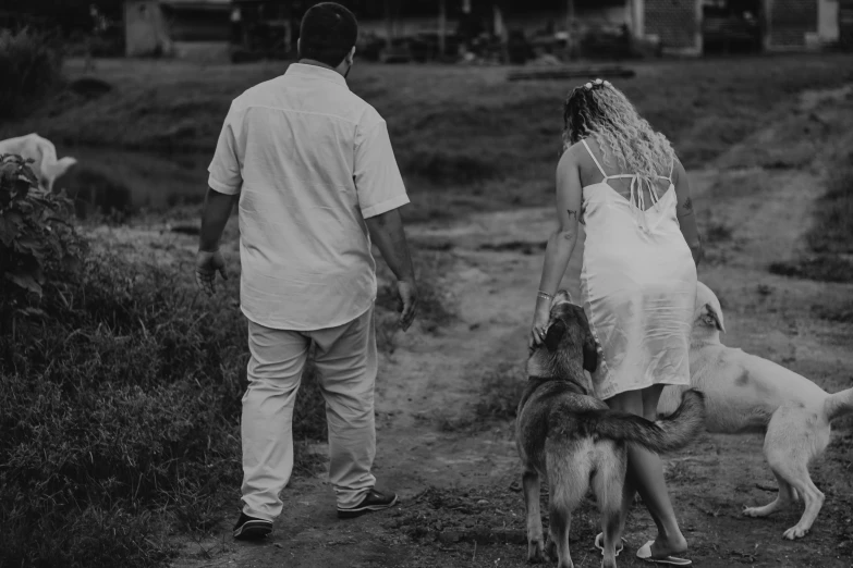 the man and woman are walking with their dogs