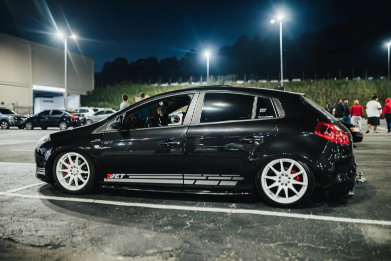 a black car parked on top of a parking lot at night