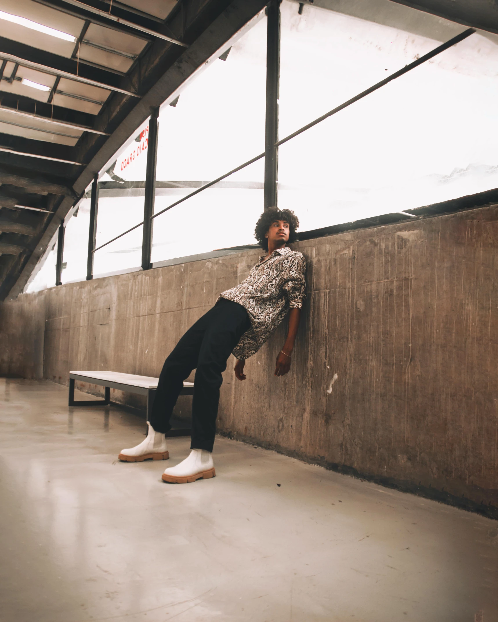 the young woman is leaning on the wall