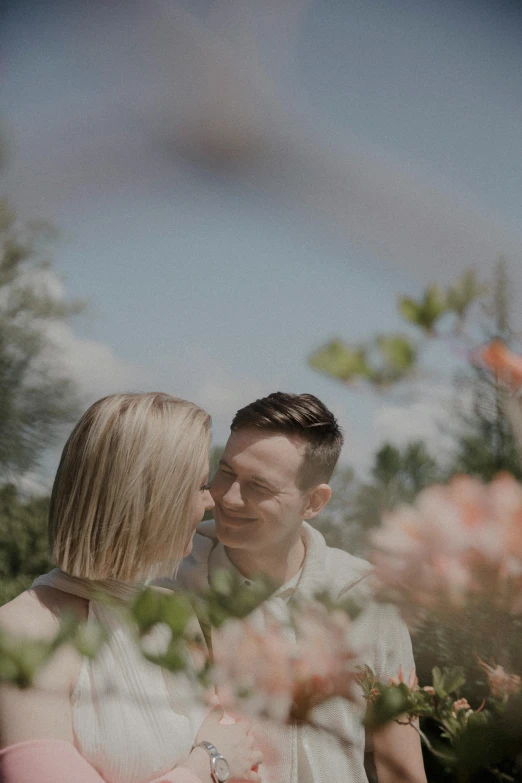 two people holding each other close to one another while the man looks down on the woman