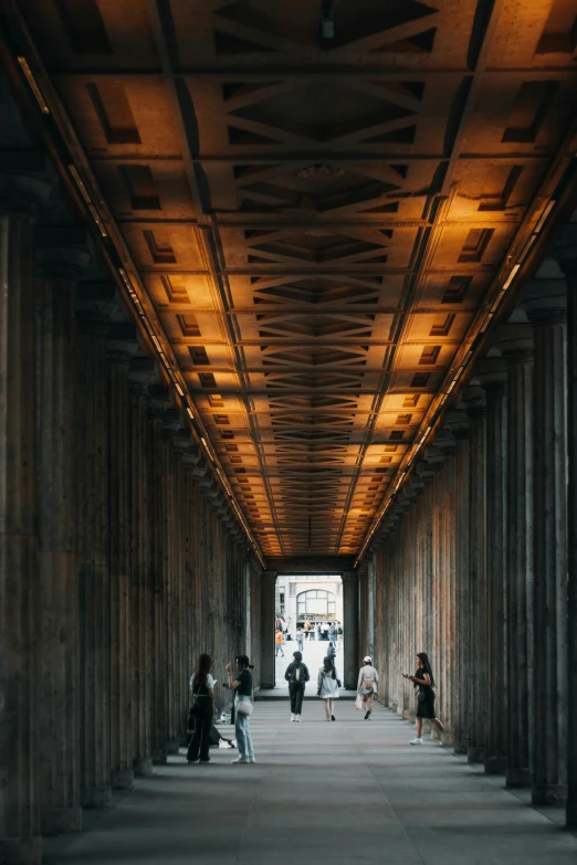 the people walk up and down the walkway under a bridge