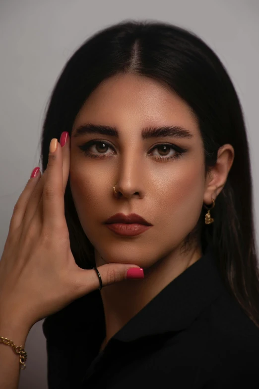 a model with pink and green nails, wearing her ring and black dress