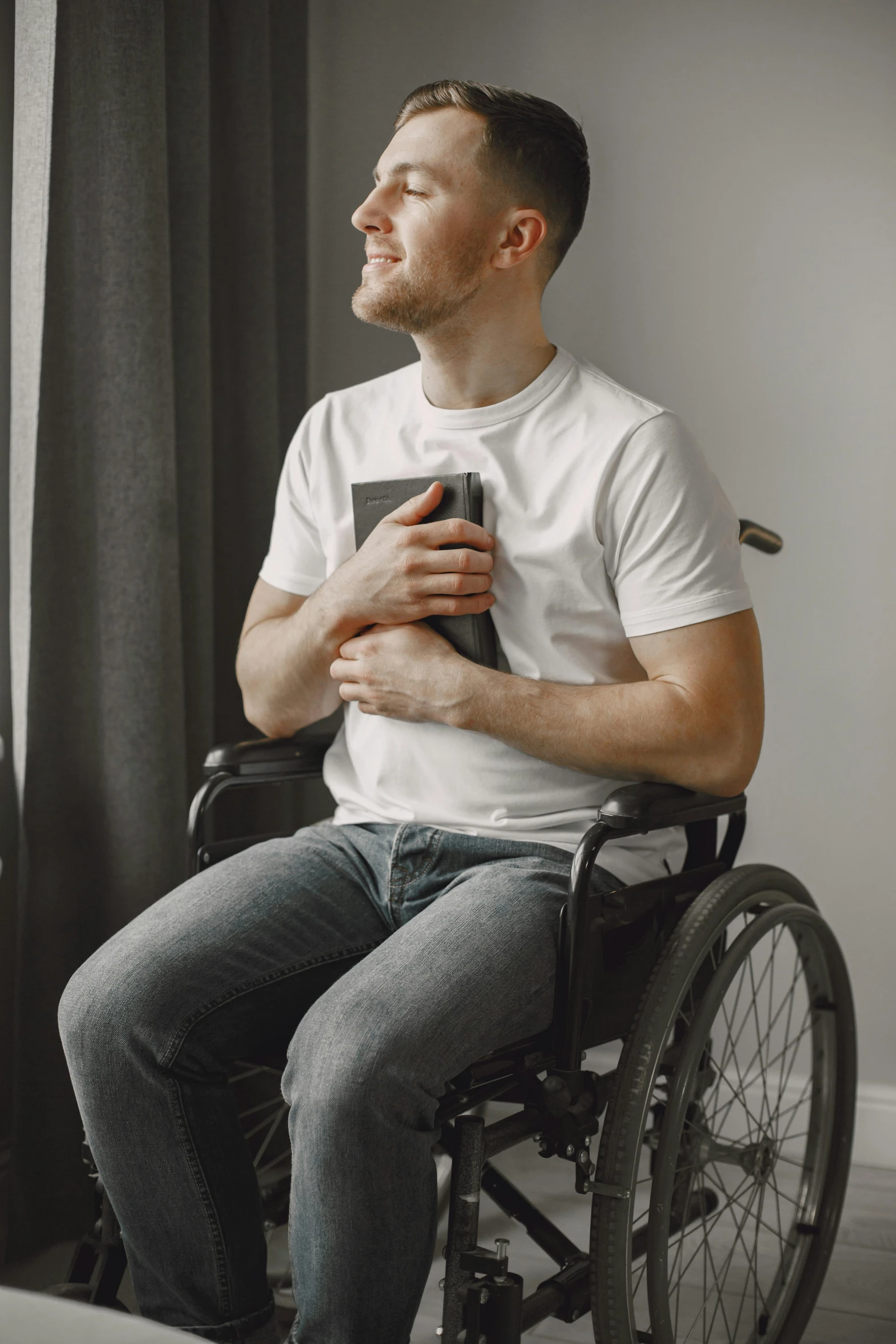 the man is sitting in a wheelchair and reading