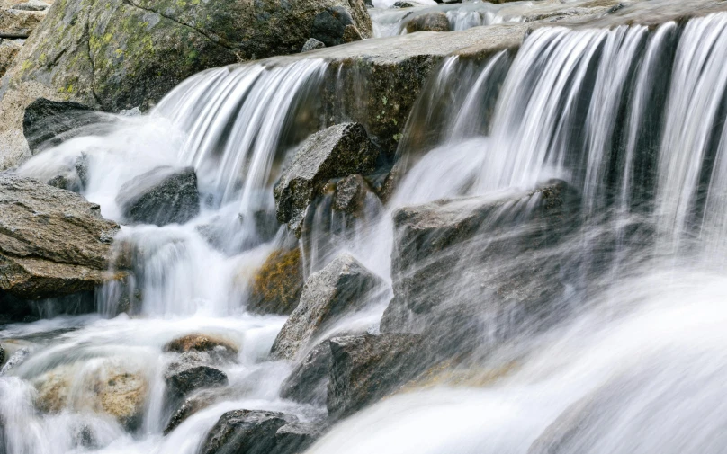 a large waterfall with multiple streams and boulders