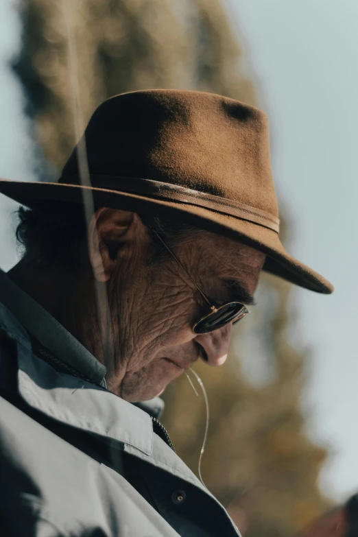 an old man with eye glasses looking through a glass