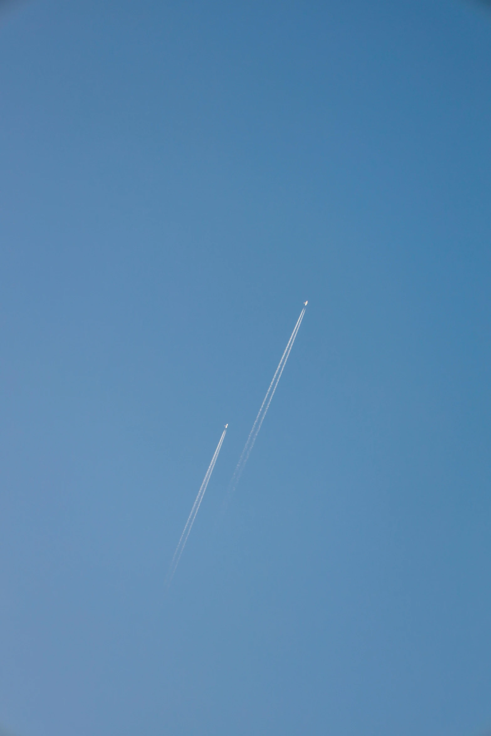 an airplane flying in a blue sky as it is contrail