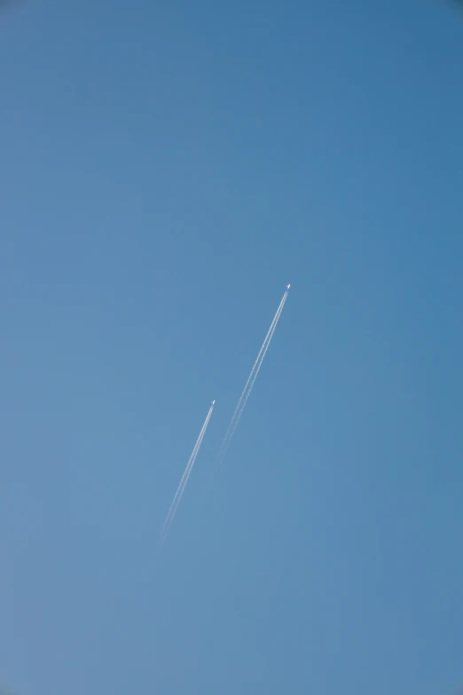 an airplane flying in a blue sky as it is contrail