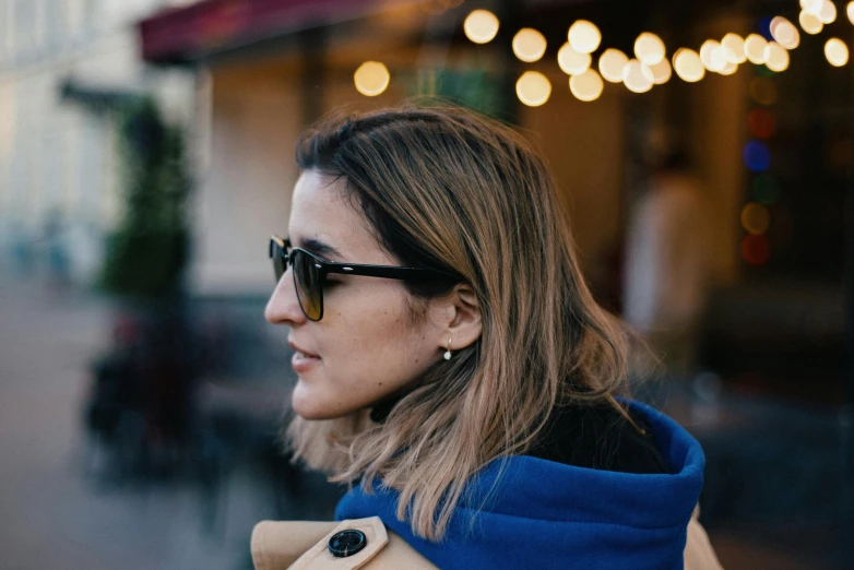 the woman wearing sunglasses is standing in front of the building