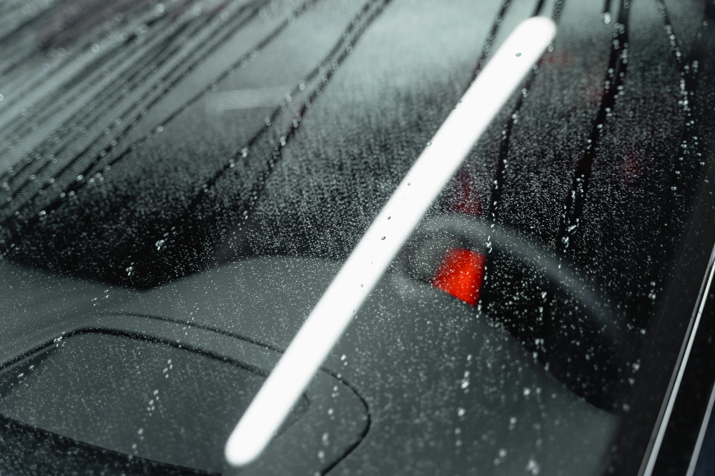 the inside view of a car windshield covered in water droplets