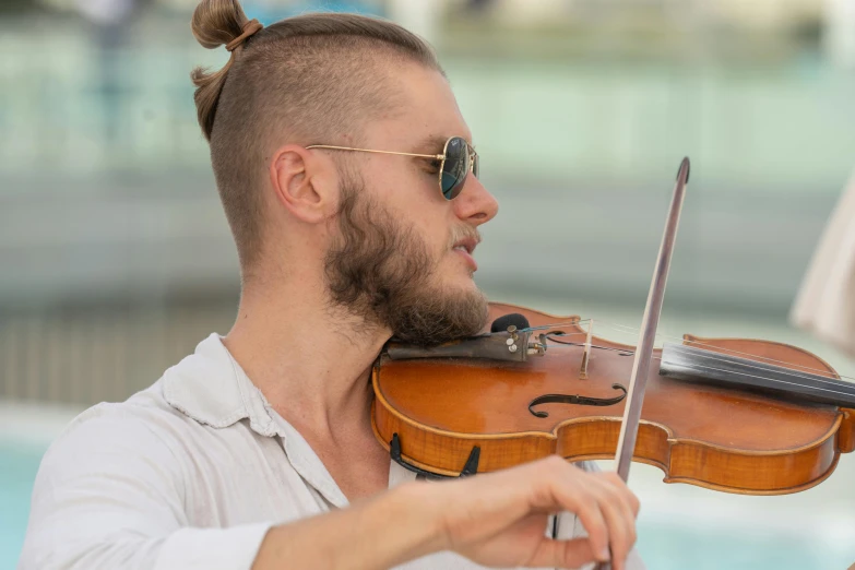 a man in a white shirt plays the violin