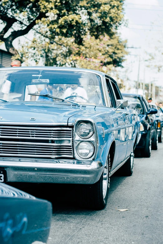 a blue classic car sitting next to other old cars