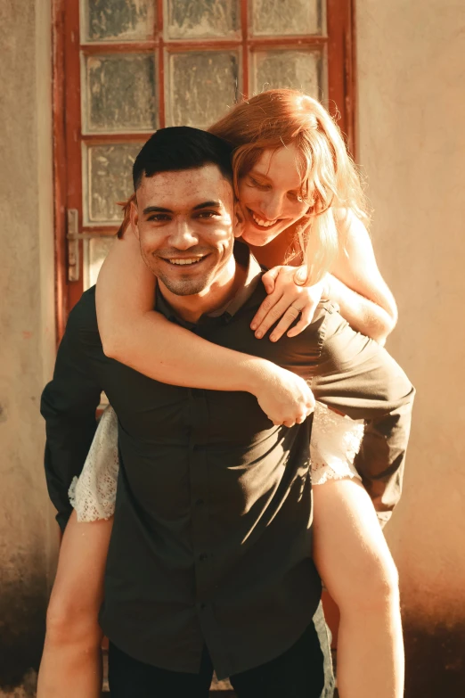 a man carries a woman as he emces her on his back