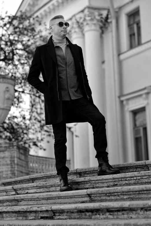 a man in a suit standing on some steps