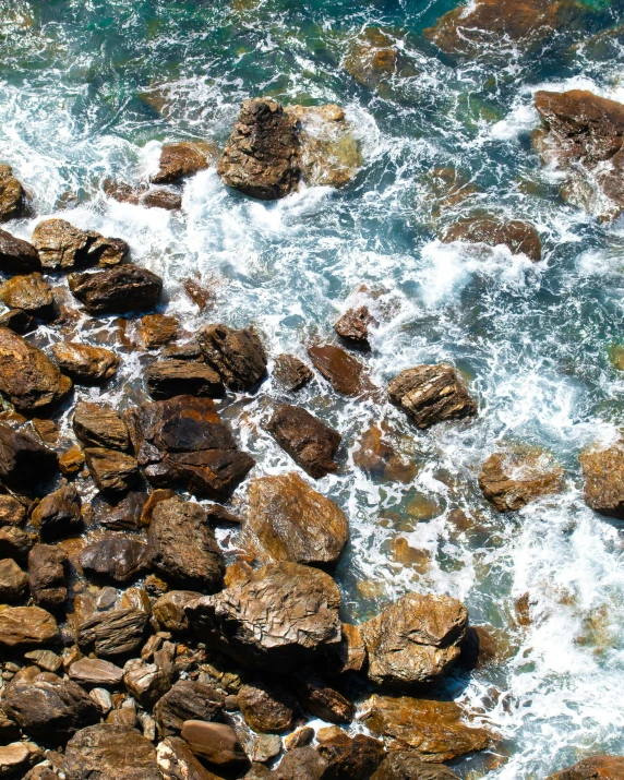 rocks in the ocean with waves hitting them