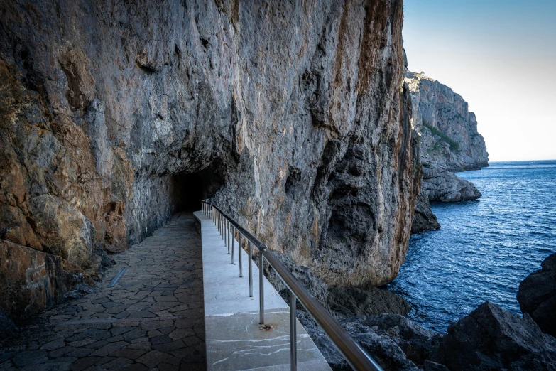 the tunnel is next to the water near the mountains