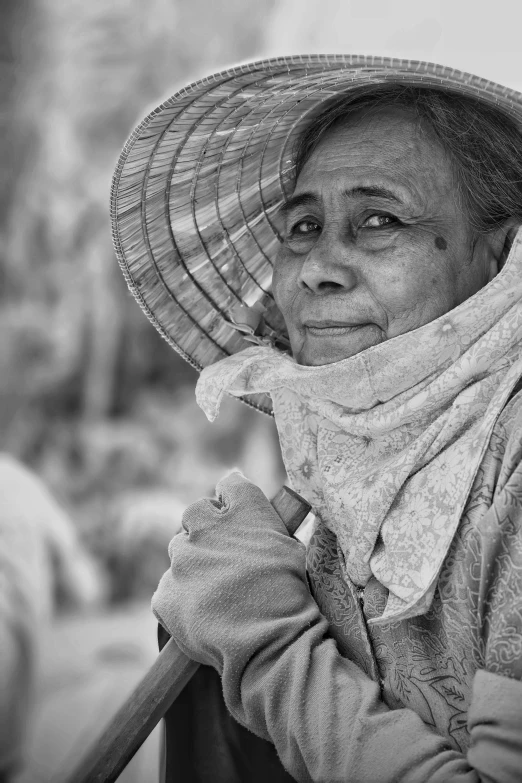 a lady with her head tilted is wearing a large hat