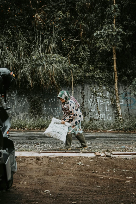 a woman hing her shopping bag down the road