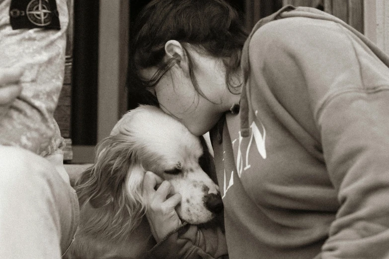 a lady is holding her dog in her arms